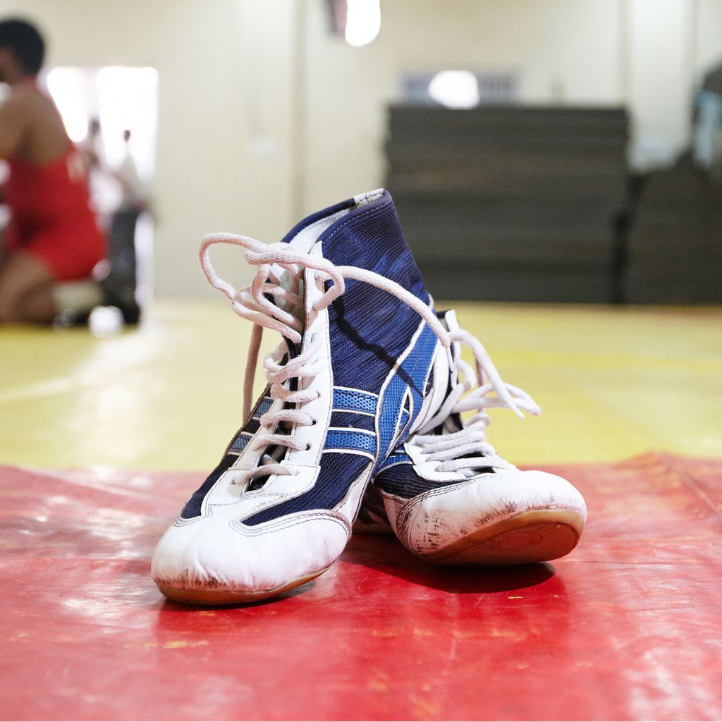A pair of wrestling shoes on a mat, representing the wrestling spirit wear collection with personalized gear for wrestling parents and fans.